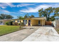 Bright yellow house with carport and well-maintained lawn at 4806 Hollyberry Dr, Orlando, FL 32812