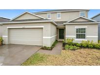 Two-story house with a two-car garage and landscaped front yard at 5627 Costa Blanca Way, Davenport, FL 33897