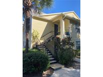 Two-story condo building with exterior stairs, landscaping, and a palm tree at 1079 S Hiawassee Rd # 1127, Orlando, FL 32835