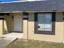 Tan colored house with dark brown trim, black roof, and a white door at 2233 Silver Pines Pl # 506, Orlando, FL 32808