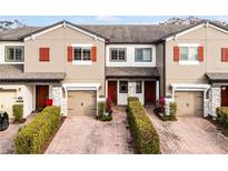 Three-unit townhome building with two-car garages and landscaped front yards at 2909 Econ Landing Blvd, Orlando, FL 32825