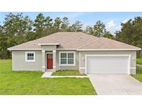 Newly constructed one-story home with attached garage and red front door at 3089 Sw 130Th Ln, Ocala, FL 34473