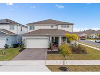 Two-story house with gray and white siding, a three-car garage, and a landscaped yard at 985 Savannah Palms Blvd, Orlando, FL 32828