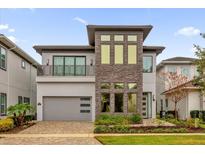 Modern two-story home with stone accents and a three-car garage at 1038 Jack Nicklaus Ct, Kissimmee, FL 34747