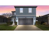 Two-story house featuring a gray exterior, two-car garage, and well-manicured lawn at 1101 Atlantic Ave, Fruitland Park, FL 34731