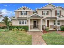 Two-story townhome with a brick walkway and landscaping at 13805 Bressler Aly, Windermere, FL 34786