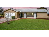 Charming ranch home with a well-manicured lawn and attached garage at 2207 Winter Woods Blvd, Winter Park, FL 32792