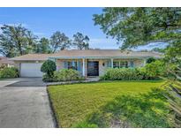 Charming single-story home featuring a brick facade, well-manicured lawn, and double door entry at 4130 Floralwood Ct, Orlando, FL 32812