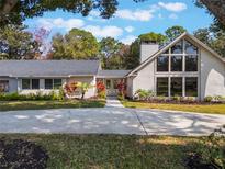 Beautiful home with a modern design, featuring a spacious driveway and lush landscaping at 601 Sweetwater Club Blvd, Longwood, FL 32779