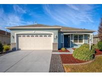 One-story house with light blue exterior, white garage door, and landscaped yard at 8134 Sw 78Th Terrace Rd, Ocala, FL 34476