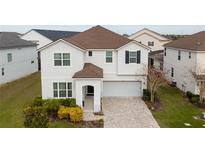 Two-story house with a white exterior, brown roof, and a paved driveway at 8953 Hilton Ridge Ave, Kissimmee, FL 34747