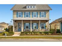 Two-story house with blue shutters, front porch, and landscaping at 9203 Neher St, Orlando, FL 32827