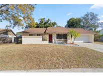 Single-story house with brown roof, red door, and landscaped front yard at 1163 Queen Elaine Dr, Casselberry, FL 32707