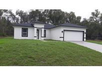 Charming single-story home featuring a modern design and well-maintained lawn at 13215 Sw 41St Ct, Ocala, FL 34473