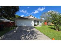 Cute one-story house with a grassy yard and attached garage at 13823 Glasser Ave, Orlando, FL 32826