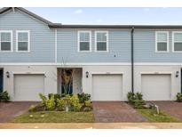 Three-unit townhome building with attached garages and landscaped front yards at 2058 Crape Jasmine Ln, Orlando, FL 32824