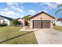 Charming single-story home with a well-manicured lawn and a two-car garage in a sunny neighborhood at 2463 Hybrid Dr, Kissimmee, FL 34758