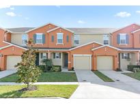 Attractive two-story townhome with a two-car garage and well-manicured landscaping at 5120 Adelaide Dr, Kissimmee, FL 34746