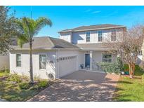 Charming two-story home boasts a brick driveway, a two-car garage, and a well-maintained lawn at 6124 Cypress Hill Rd, Winter Garden, FL 34787