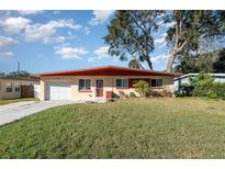 Ranch style home with a red roof and a well-maintained lawn at 716 Katherine St, South Daytona, FL 32119