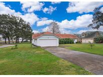 House with attached garage, landscaped yard, and waterfront view at 808 N Shore Dr, Leesburg, FL 34748
