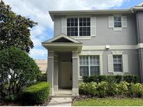 Charming two-story townhouse with covered entrance, lush landscaping, and neutral gray tones at 8634 Danforth Dr, Windermere, FL 34786