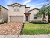 Two-story house with a two-car garage and brick paver driveway at 8884 Bengal Ct, Kissimmee, FL 34747