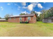 Charming single-story home featuring solar panels and a spacious front yard, offering energy efficiency and curb appeal at 9877 7Th Ave, Orlando, FL 32824