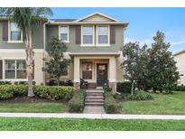 Two-story green house with brown accents, front porch, and landscaped yard at 9979 Schroeder Aly, Winter Garden, FL 34787
