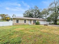 Ranch style home with a well-maintained lawn and a white picket fence at 1018 Bear Lake Rd, Apopka, FL 32703