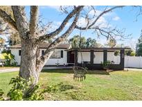 Charming ranch home with a covered porch and well-manicured lawn at 117 Temple St, Deland, FL 32720