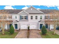 Two-story townhouses with gray siding, blue doors, and paved driveways at 190 Mitchell Creek Way, Oviedo, FL 32765