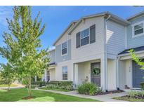 Two-story townhome with light blue siding, landscaping, and a welcoming front porch at 2102 Gopher Tortoise Ter, Oakland, FL 34787