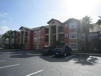 Apartment building with parking lot and landscaping at 2216 Grand Cayman Ct # 1411, Kissimmee, FL 34741