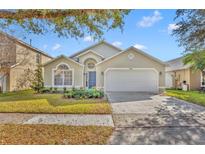 Charming single-Gathering home featuring a manicured lawn and a two-car garage at 233 Bluejay Way, Orlando, FL 32828