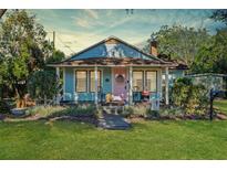 Charming bungalow with a pink door, front porch, and well-maintained lawn at 549 Glenway Dr, Sanford, FL 32771