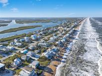 Beautiful aerial view of beach houses along the coast with ocean and inlet views on a sunny day at 6912 S Atlantic Ave, New Smyrna Beach, FL 32169