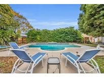 Inviting backyard pool with lounge chairs and lush landscaping, perfect for relaxation and outdoor enjoyment at 137 S Deerwood Ave, Orlando, FL 32825
