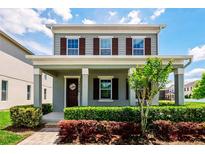 Charming two-story home featuring a welcoming front porch and well-maintained landscaping at 14310 Shocklach Dr, Winter Garden, FL 34787