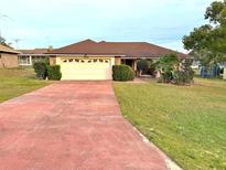 Single-story home with attached garage and well-maintained lawn at 150 S Carolina Ave, Lake Alfred, FL 33850