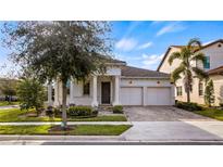 Two-car garage, white exterior, and a nicely landscaped front yard at 15810 Shorebird Ln, Winter Garden, FL 34787