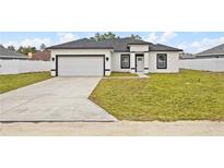 Newly constructed home with attached garage and spacious lawn at 16895 Sw 50Th Cir, Ocala, FL 34473