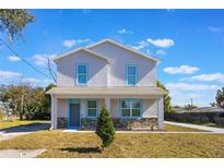 Two-story house with light gray siding, blue trim, and stone accents at 1707 Merthie Dr, Sanford, FL 32771