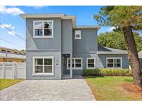 Two-story home with a modern gray facade, white window trim, and a paved driveway, offering curb appeal at 1875 Staunton Ave, Winter Park, FL 32789