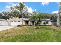 Single-story house with stone facade, attached garage, and well-maintained lawn at 2507 Maui Cir, Kissimmee, FL 34741