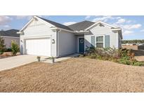 Gray one-story house with white garage door and landscaping at 7518 Sw 77Th Ave, Ocala, FL 34481