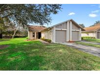 Exterior view of a charming villa with a two-car garage and well-manicured lawn at 180 Hill St # 180, Casselberry, FL 32707