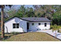 The house features a clean and simple exterior with a well-manicured lawn and fresh landscaping at 2033 N Orange St, Mount Dora, FL 32757