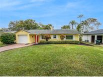Charming yellow house with a brick driveway and well-manicured lawn at 2111 Staunton Ave, Winter Park, FL 32789