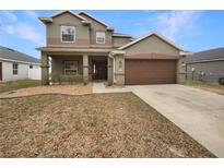 Two-story house with attached garage and landscaped lawn at 4047 Sw 51St Ct, Ocala, FL 34474